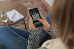 Ragazza di spalle seduta sul divano che guarda il cellulare