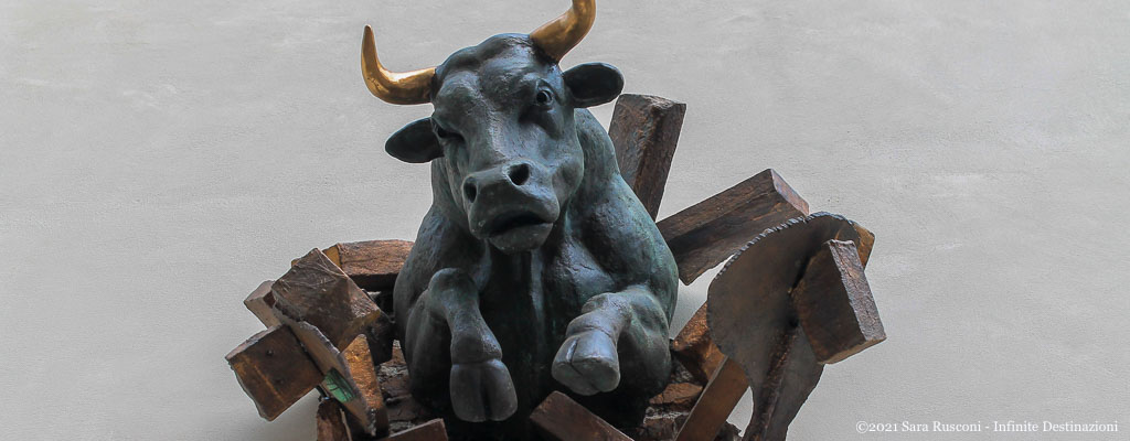 T'Oro: installazione di un toro con le corna d'oro che sfonda un muro